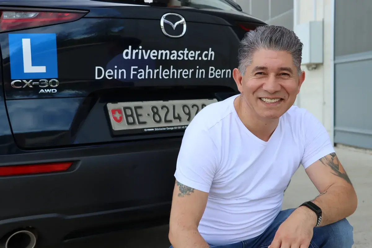 Fahrlehrer Mishel Memedovski vor dem Drivemaster Fahrschulauto – dein Fahrlehrer für Münsingen und Bern
